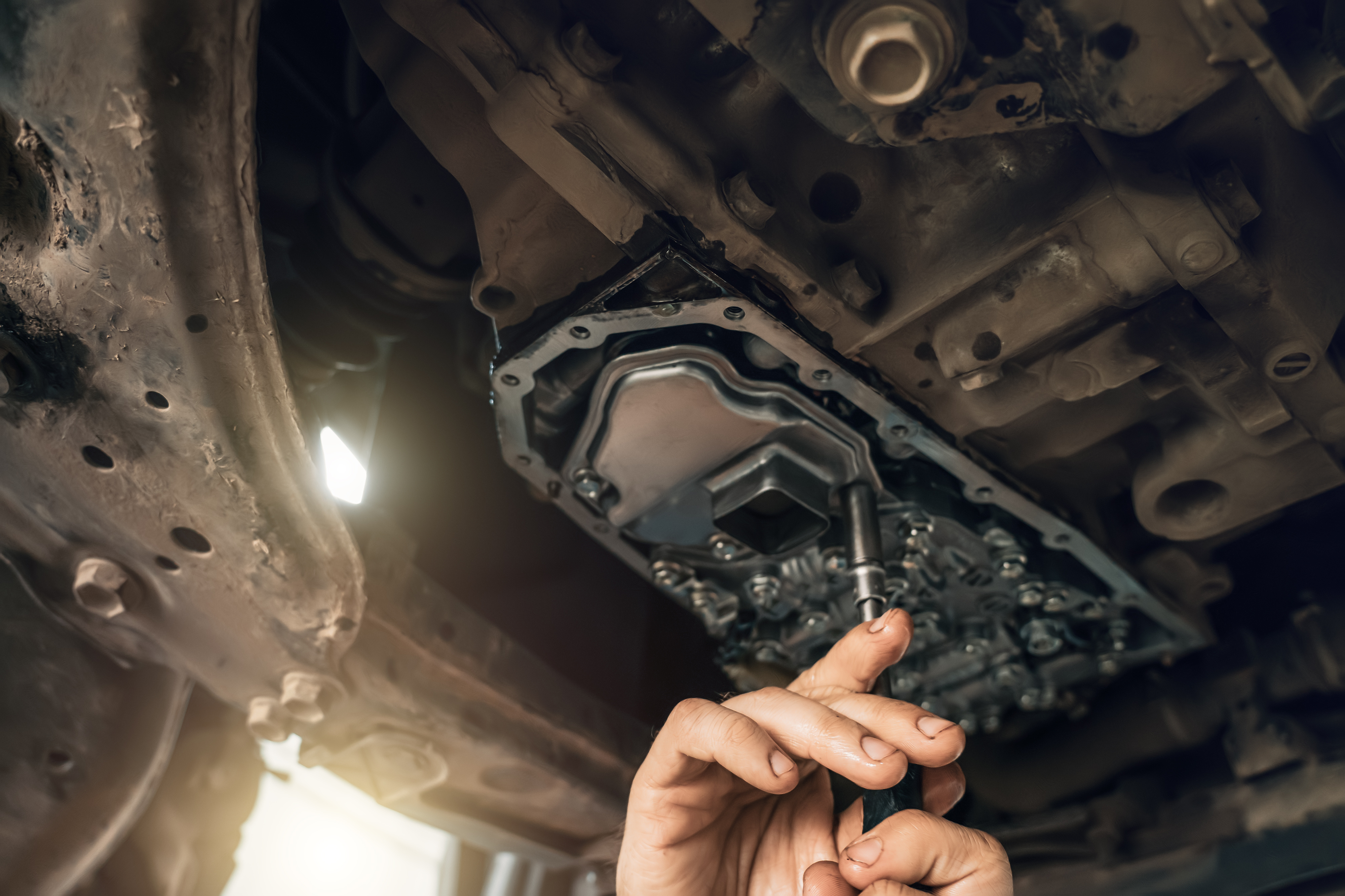 Technician performing transmission diagnostics under a vehicle