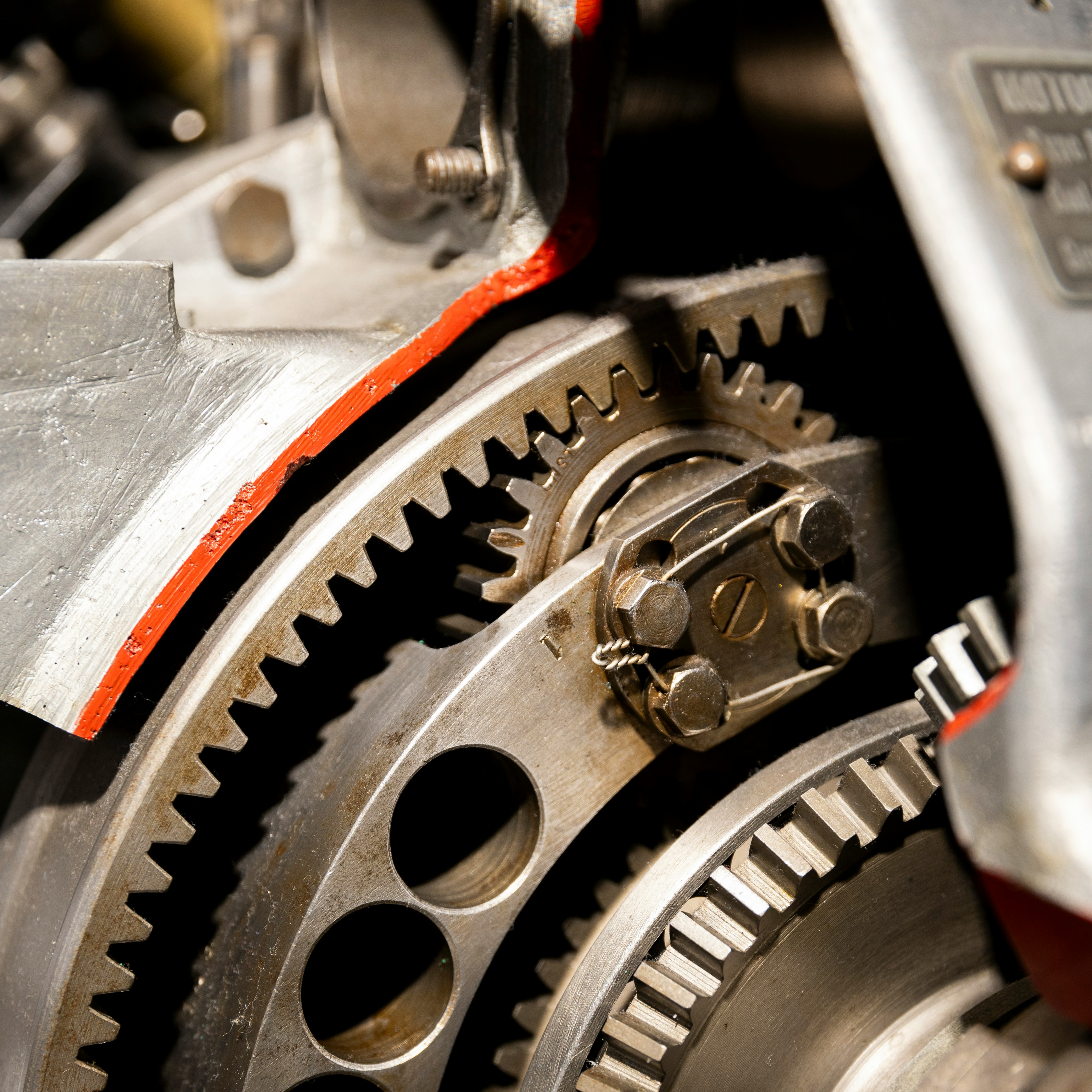 Close-up of a gear train with red accents — transmission components